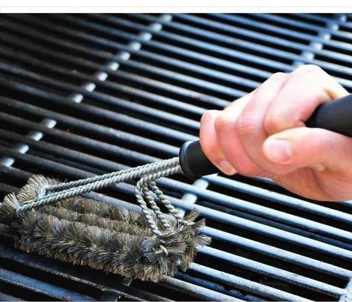 Cleaning a grill at a summer barbecue party.
